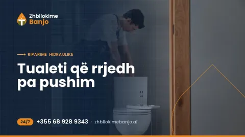 Hidraulik me vegla pune në banjë duke kontrolluar tualetin dhe rezervuarin e WC-së